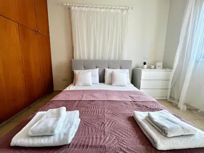 a bedroom with a large bed with two towels on it at STAY Tranquility Cove in Larnaka