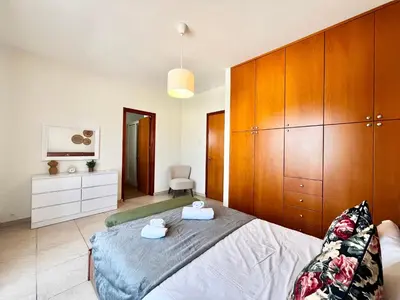 a bedroom with a large bed and wooden cabinets at STAY Tranquility Cove in Larnaka