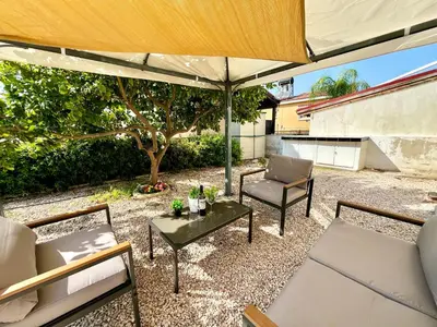 a patio with a table and chairs and an umbrella at STAY Tranquility Cove in Larnaka