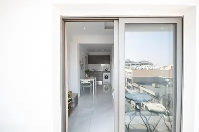 a sliding glass door leading to a balcony with a table at Quattro City Center Ap 501B in Larnaka