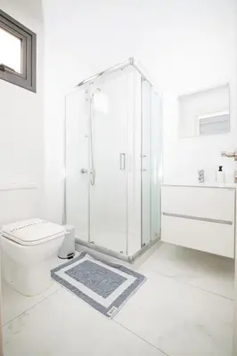 a white bathroom with a shower and a toilet at Quattro City Center Ap 501B in Larnaka