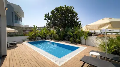 a swimming pool on a patio with an umbrella at City Napa Seaview Villas - Villa 5 in Ayia Napa