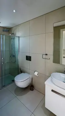 a bathroom with a toilet and a glass shower at City Napa Seaview Villas - Villa 6 in Ayia Napa