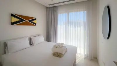 a white bedroom with a teddy bear sitting on a bed at City Napa Seaview Villas - Villa 6 in Ayia Napa