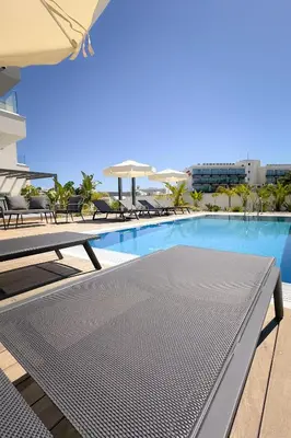 a swimming pool with tables and chairs on a building at City Napa Seaview Villas - Villa 6 in Ayia Napa