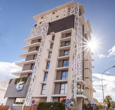 a tall building with a white facade at Gaia Seaview Apartment 2 in Larnaka