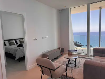 a bedroom with a bed and a view of the ocean at Ayia Napa Marina Exclusive Apartment in Ayia Napa
