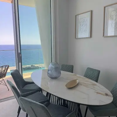 a table and chairs in a room with a view of the ocean at Ayia Napa Marina Exclusive Apartment in Ayia Napa