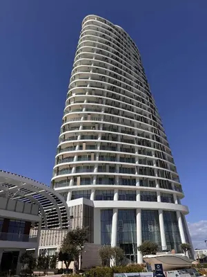 a tall white building with a lot of windows at Ayia Napa Marina Exclusive Apartment in Ayia Napa