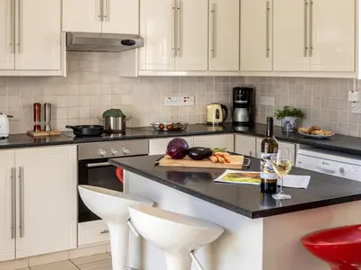 a kitchen with white cabinets and a counter with wine glasses at Villa Alexandra in Protaras