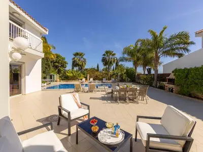 a patio with chairs and a table and a pool at Villa Alexandra in Protaras
