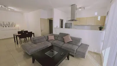 a living room with a couch and a table at STAY White Petals Apartment in Larnaka