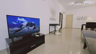 a living room with a flat screen tv and a piano at STAY White Petals Apartment in Larnaka