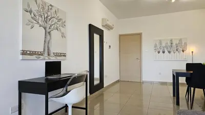 a desk with a laptop and a chair in a room at STAY White Petals Apartment in Larnaka