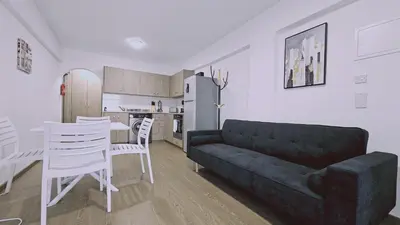 a living room with a couch and a table and a kitchen at STAY Blissful Apartment in Protaras