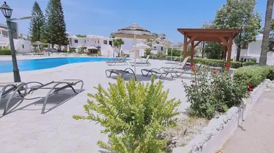 a group of chairs and a pool in a resort at STAY Blissful Apartment in Protaras