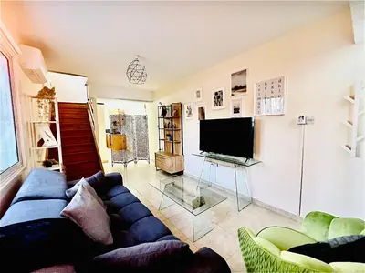 a living room with a blue couch and a television at KAMILA 5 in Voroklini