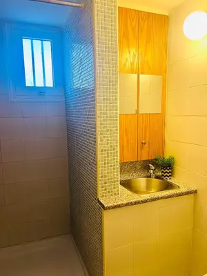 a yellow bathroom with a sink and a shower at KAMILA 5 in Voroklini