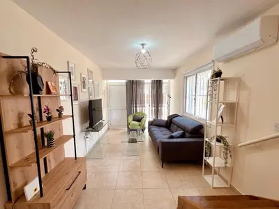 a living room with a couch and a tv at KAMILA 5 in Voroklini