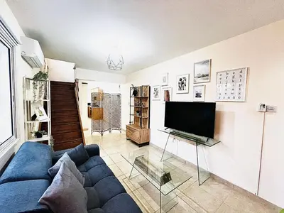 a living room with a blue couch and a tv at KAMILA 5 in Voroklini
