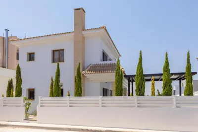a white house with a fence and trees at SunnyVillas-3BR New Modern Villa-Private Pool-HVN in Paralimni