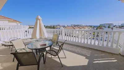 a patio with a table and chairs and an umbrella at Nissi Golden Sands Privileges Apt in Ayia Napa
