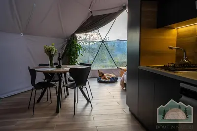 a dining room with a table in a tent with a dog at Dome in Nature in Larnaka