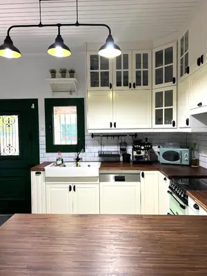 a kitchen with white cabinets and a wooden counter top at The Fig Tree House in Lofou