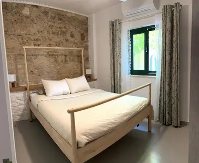 a bed in a room with a brick wall at The Fig Tree House in Lofou