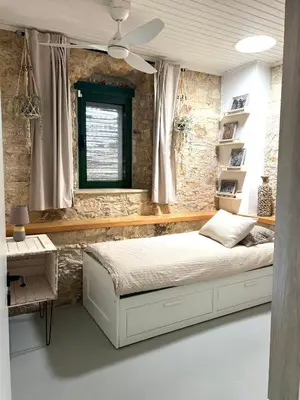 a bedroom with a bed and a desk and a window at The Fig Tree House in Lofou