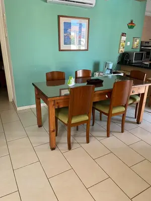 a dining room with a wooden table and chairs at POSEIDONIA BEACH GARDENS in Paralimni