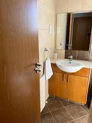a bathroom with a sink and a mirror at POSEIDONIA BEACH GARDENS in Paralimni