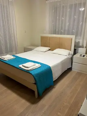 a bedroom with a large bed with a blue blanket at POSEIDONIA BEACH GARDENS in Paralimni