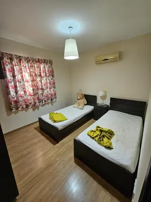 two beds in a room with a teddy bear sitting on top at STEFARIS sea & mountain view in Larnaka