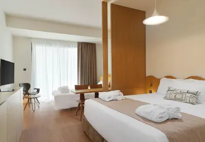 a hotel room with a large bed and a desk at Alinea Market Agora Square in Limassol
