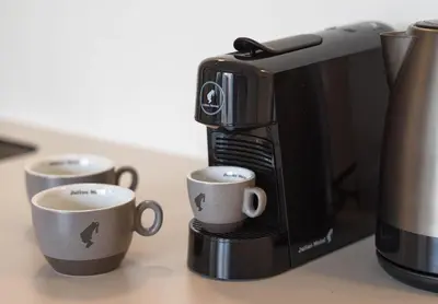 a coffee maker with two cups on a counter at Alinea Market Agora Square in Limassol