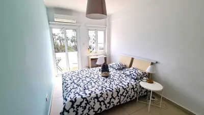 a bedroom with a bed and a table with a lamp at City Center: Your Urban Retreat- 100m to the beach in Larnaka