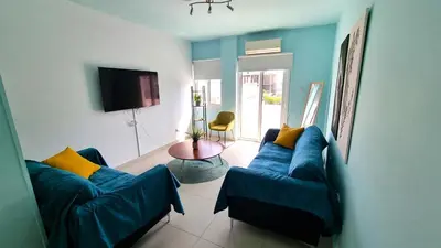 a living room with two blue couches and a table at City Center: Your Urban Retreat- 100m to the beach in Larnaka