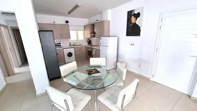 a kitchen with a glass table and white chairs at City Center: Your Urban Retreat- 100m to the beach in Larnaka