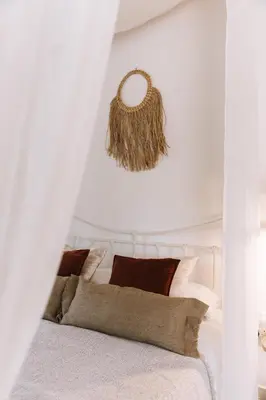 a bedroom with a white bed with brown pillows at Anerada Cottages in Apsiou