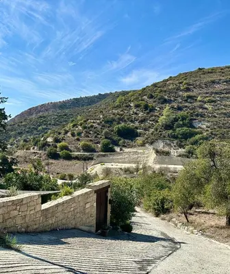 a stone wall with a mountain in the background at Anerada Cottages in Apsiou