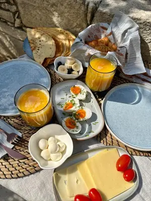 a table with plates of food and bowls of food at Anerada Cottages in Apsiou
