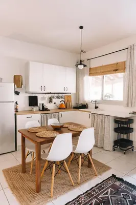 a kitchen with a wooden table and white cabinets at Anerada Cottages in Apsiou