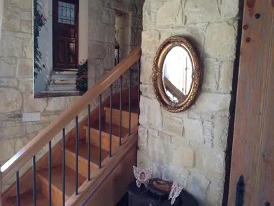 a staircase with a round mirror on a stone wall at Lofou Traditional Stone House in Lofou