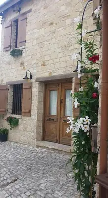 a stone building with a wooden door and flowers at Lofou Traditional Stone House in Lofou