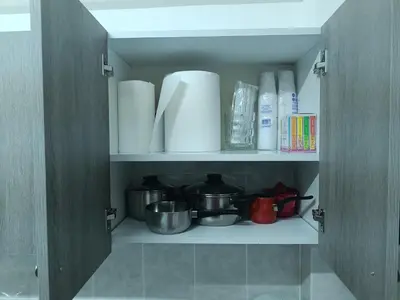 a cupboard filled with lots of white plates and dishes at Sea-side City centre Studio in Larnaka