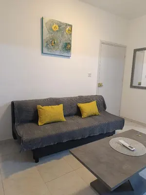 a couch with two yellow pillows in a living room at Sea-side City centre Studio in Larnaka
