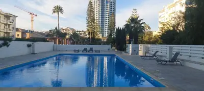 a swimming pool with chairs and a building at Coco De Mer 408 in Limassol