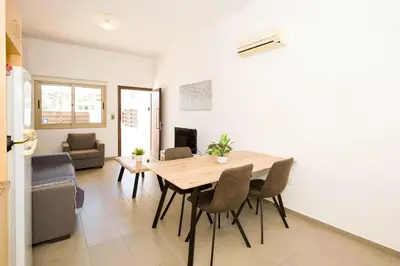a kitchen and dining room with a table and chairs at Bowker Apartment in Protaras
