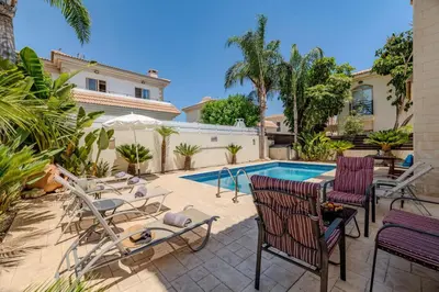 a patio with chairs and a swimming pool at Alex Villa Kapparis in Protaras